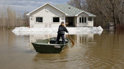 JOE.BRYKSA@FREEPRESS.MB.CA  Local- ( See   Sandy's   story)-  Rm CartierSharon Ezako makes her way to her home  in the RM of Cartier Sunday afternoon-Their house is surrounded by nearly a meter deep water- Rising waters from the flooding Assiniboine River has put 40 homes in the area at risk of flooding- JOE BRYKSA/WINNIPEG FREE PRESS- May 08, 2011