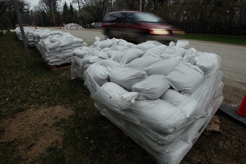 KEN GIGLIOTTI / WINNIPEG FREE PRESS / May 10 2011 - Flood 2011 Assiniboine River - Getting Ready in South  Headingley - Sand bags are piled and an appeal is out for volunteers help out raising the dikes  by 2 ft. -recent  rains has raised concerns about flooding ninth area already  diked with  clay dikes ,sandbags and tiger dikes . Volunteers are to  meet at the Headlingley Food Store along Roblin  Blvd at 9am