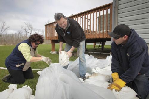 MIKE.DEAL@FREEPRESS.MB.CA 110511 - Wednesday, May 11, 2011 -  (l-r) Homeowners Lynn and Les Kauppila along with Kelly Chabot start building a sandbag dike around their home. The Kauppila's lost there home in when a tornado hit Elie in 2007. MIKE DEAL / WINNIPEG FREE PRESS