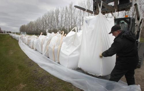 MIKE.DEAL@FREEPRESS.MB.CA 110513 - Friday, May 13, 2011 -  Dave Hofer guides a massive sand filled bag into place along the main road into the Starlite Hutterite Colony close to Starbuck. MIKE DEAL / WINNIPEG FREE PRESS