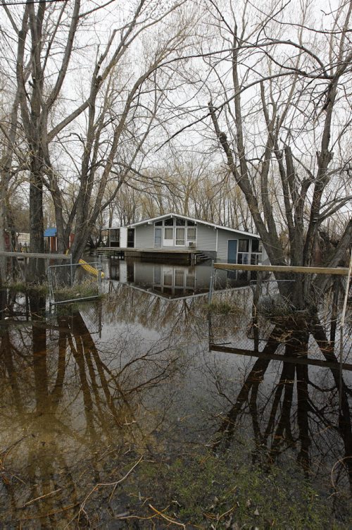TREVOR HAGAN / WINNIPEG FREE PRESS - Two cottages on Mackenzie Bay South are already fully surrounded by water in the Twin Lakes Beaches area. 11-05-13