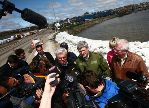 Brandon Sun Premier Greg Selinger and Prime Minister Stephen Harper take a few questions of the media next the sandbag dike along 18th Street on Wednesday afternoon. (Bruce Bumstead/Brandon Sun)