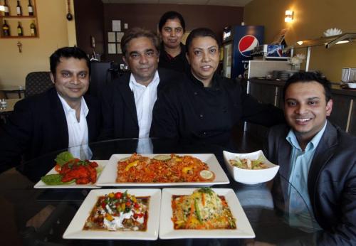 BORIS.MINKEVICH@FREEPRESS.MB.CA   BORIS MINKEVICH / WINNIPEG FREE PRESS 110518 Water Lily restaurant- l-r. Rashid Islam, (behind Narmin back) Pinky Singh, Narmin Biswas, Rana Biswas, and Antu Biswas, pose for a photo with some most wonderful dishes they serve at the east Indian restaurant across from St. Vital Centre.