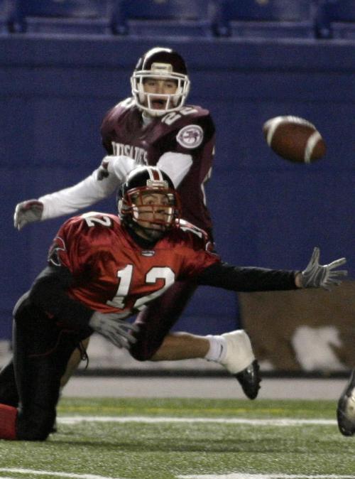 John Woods / Winnipeg Free Press / November 10, 2006 - 061110  - Sisler Spartan Trevor Taylor (12) stretches out for the pass with coverage from St Paul's Crusader Marshall Williams (22) in the first half of the WHSFL finals at Canad Inns Stadium Friday Nov 10/06.