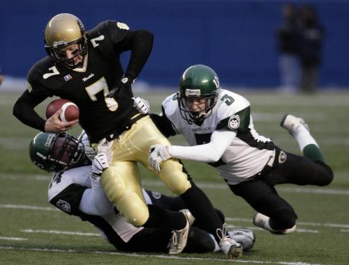 John Woods / Winnipeg Free Press / November 11, 2006 - 061111 - U of S Huskies Brian Guebert (14) and Jordy Burrows (3) grab hold of Bisons QB John Makie (7) as he runs for yards in the first half of the west division finals Saturday Nov 11/06.
