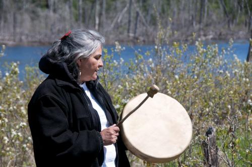 credit Pimachiowin Aki tour photographer J.J. Ali UNESCO bid tour on the Bloodvein River Bloodvein River First Nation traditional teacher Martina Fisher sings with hand drum on the shores of the Bloodvein River for dignitaries. for Alex Paul story in Winnipeg Free Press
