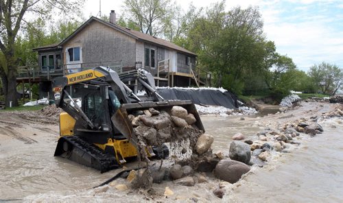 JOE.BRYKSA@FREEPRESS.MB.CA  Twin Lakes Beach- ( See   story)-  Heavy equipment works to make a breakwater in the front of two cottages  in Twin Lakes Beach Monday afternoon- Flooding from Lake Manitoba has given the local municipality a state of emergency so they can have access the cottages . Last week heavy winds caused flooding one road  that gives access to cottagers and full time residents-JOE BRYKSA/WINNIPEG FREE PRESS- May 30, 2011