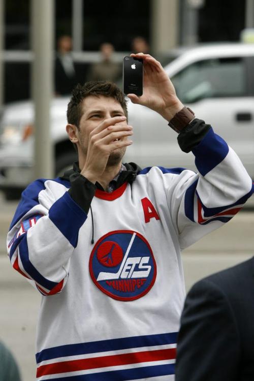 MIKE.DEAL@FREEPRESS.MB.CA 110531 - Tuesday, May 31, 2011 -  Hockey fans gathered at Portage and Main to celebrate the return of the NHL to Winnipeg, MB. Mark Zwaagstra takes photos of the crowd watching the press conference on the Global big screen. MIKE DEAL / WINNIPEG FREE PRESS