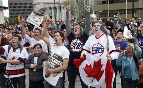 KEN GIGLIOTTI / WINNIPEG FREE PRESS / May 31 2011 - Fans cheer announcement made over closed circuit outdoor TV  Canwest Place at Portage Ave  and Main St. just before noon - NHL comes back to Winnipeg - True North Sports and Entertainment  announced they have  acquired the Atlanta Thrashers and bringing the team back to Winnipeg. Celebrations took place  at historic corner of Portage Ave  and Main starting with a small group at 7am  to a large crowd that closed the intersection from the late morning to early afternoon just after the announcement was confirmed - return of the Jets -  kgjets  brings most of Wpg  Jets photos in Merlin