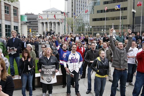 KEN GIGLIOTTI / WINNIPEG FREE PRESS / May 31 2011 - Fans cheer announcement made over closed circuit outdoor TV  Canwest Place at Portage Ave  and Main St. just before noon - NHL comes back to Winnipeg - True North Sports and Entertainment  announced they have  acquired the Atlanta Thrashers and bringing the team back to Winnipeg. Celebrations took place  at historic corner of Portage Ave  and Main starting with a small group at 7am  to a large crowd that closed the intersection from the late morning to early afternoon just after the announcement was confirmed - return of the Jets -  kgjets  brings most of  Jets photos in Merlin