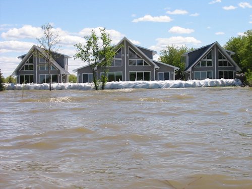 Dauphin Lake Flood - A cottage, flanked by two guest houses, valued at close to $1 million, sits protected behind sandbag dike on Dauphin Lake. Bill Redekop story/photo. Winnipeg Free Press. June 08 2011.
