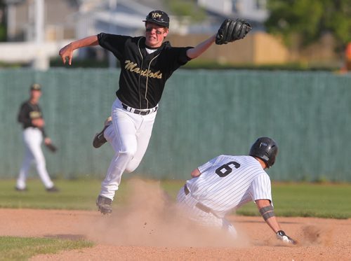 Brandon Sun Montana Marlins' Kevin Clarks slide safely under the throw to Team Manitoba's Brady Bouchard during their exhibition game at Andrews Field on Friday. (Bruce Bumstead/Brandon Sun)