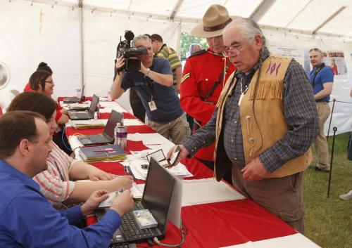 BORIS.MINKEVICH@FREEPRESS.MB.CA   BORIS MINKEVICH / WINNIPEG FREE PRESS 110614 Elder Garry Robson gets his $5 right after the opening ceremony of Urban Treaty Payments at The Forks National Historic Site.