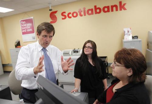 BORIS.MINKEVICH@FREEPRESS.MB.CA   BORIS MINKEVICH / WINNIPEG FREE PRESS 110629 Scotiabank President and CEO Rick Waugh visits his old bank in Windsor Park where. Here he chats with some tellers. He took pride in standing in his old teller stall.