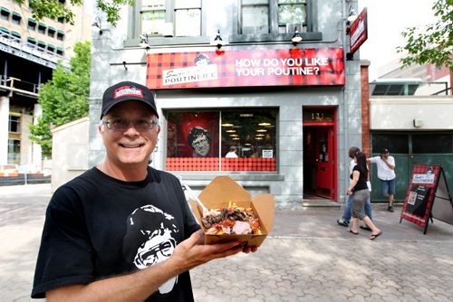 Jeff Baron, owner of Smoke's Poutinerie on Albert Street holds a large Canadiana poutine speicalty outside his store in Old Market Square.   For Xtra, Dave Conners.  July 2 2011 (RUTH BONNEVILLE / WINNIPEG FREE PRESS) NOTE: Jeff Baron is not part of the business anymore