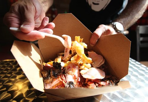 Jeff Baron, owner of Smoke's Poutinerie on Albert Street digs into a large Canadiana poutine specialty in his store in Old Market Square.   For Xtra, Dave Conners.  July 2 2011 (RUTH BONNEVILLE / WINNIPEG FREE PRESS) NOTE: Jeff Baron is not part of the business anymore
