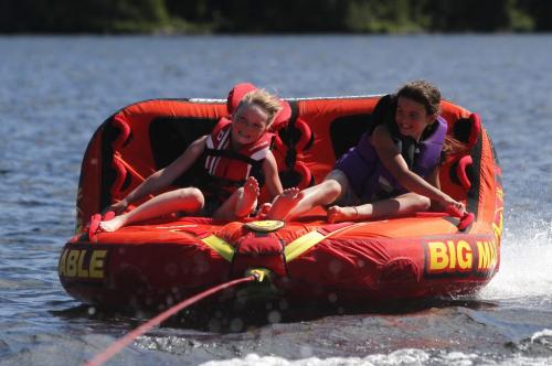 BORIS.MINKEVICH@FREEPRESS.MB.CA   BORIS MINKEVICH / WINNIPEG FREE PRESS 110702 Long Weekend fun on Longbow Lake, just east of Kenora, Ontario. A pair of 9 year olds, Nori Sigvaldason and Abby Dent  cool off while tubing behind Nori's family's new boat on the lake.
