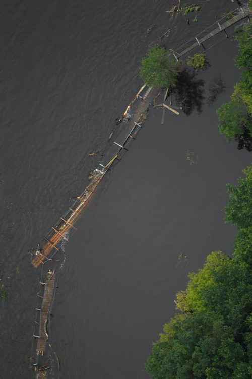 Brandon Sun 04072011 The historic swinging bridge is seen from the air in the Souris river on Monday after it was cut on the weekend due to the high river level. (Tim Smith/Brandon Sun)