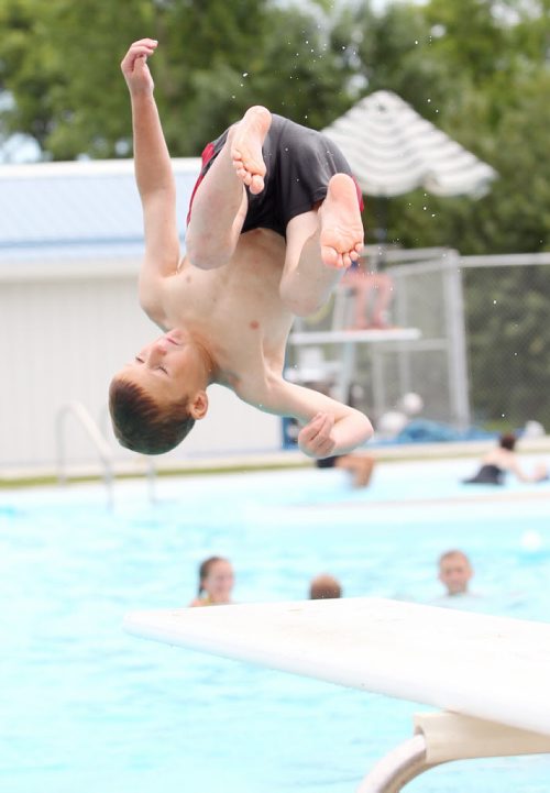 Brandon Sun 18072011 A young boy does a front filp off of the diving board on the opening day of the Wawanesa and District Water Park in Wawanesa, Man. on a scorching hot Monday afternoon. (Tim Smith/Brandon Sun)