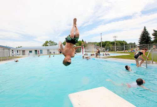 Brandon Sun 18072011 Ethan Lockhart does a front filp off of the diving board on the opening day of the Wawanesa and District Water Park in Wawanesa, Man. on a scorching hot Monday afternoon. (Tim Smith/Brandon Sun)