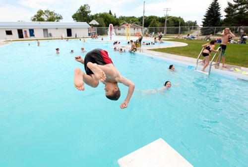 Brandon Sun 18072011 A young boy does a front filp off of the diving board on the opening day of the Wawanesa and District Water Park in Wawanesa, Man. on a scorching hot Monday afternoon. (Tim Smith/Brandon Sun)