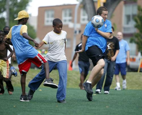 Winnipeg Police Cadets play a friendly game of soccer with kids at Central Park. Here kids Zak Mustaf and Ivan Ntale put the boots to Cadet Rob Klym. July 27, 2011 (BORIS MINKEVICH / WINNIPEG FREE PRESS)
