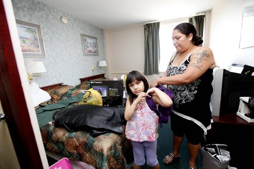 Five year old Haelynn gets help from her mom Alycia Anderson putting on her backpack as they prepare to leave their hotel room at the Marlborough Hotel that they have called home for over 3 months after being evacuated from Lake St. Martin due to flooding. Saturday Special - Melissa Martin's Flooding story. July 28, 2011 (RUTH BONNEVILLE / WINNIPEG FREE PRESS)