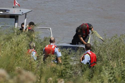 Police and firefighters attend to a car that was driven into the Red River at Pembina and Grandmont in St Norbert Saturday, July 30, 2011.  John Woods/Winnipeg Free Press