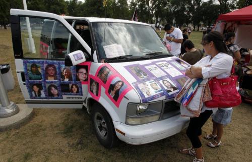 Missing women concert. To bring more awareness to the issue of violence against women and missing and murdered women across canada. A woman who chose not to give her name looks at the van that is part of the walk across Canada. August 7, 2011 (BORIS MINKEVICH / WINNIPEG FREE PRESS)