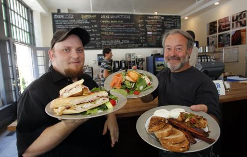 FREE PRESS CAFE - Jason Engelbretson and Domenic Amatuzuo pose for a photo with three delicious meals you can enjoy at the cafe. Cuban sandwich, Salmon Salman Salad, poached eggs with hashbrowns and bacon.  August 10, 2011 (BORIS MINKEVICH / WINNIPEG FREE PRESS)