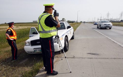 Wpg Police have found that 34% of drivers  were over the speed limit  in a two day period on Bishop Grandin , this findings have prompted a crack down - in pic left Sgt. Mark Hodgson right Sgt Lou Malo uses speed traffic laser to monitor radar speed  in the area -  Jen Skerritt Story - Police traffic Laser Enforcement for Saturday ( KEN GIGLIOTTI  / WINNIPEG FREE PRESS ) Aug 12 2011 -