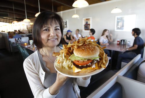 Detour story on the best burgers outside the Perimeter Hwy.  Bertha Ganas owner of Nick's Inn in Headingley,Mb. with their Deluxe Burger. Dave Sanderson story.     (WAYNE GLOWACKI/WINNIPEG FREE PRESS) Winnipeg Free Press August 17  2011