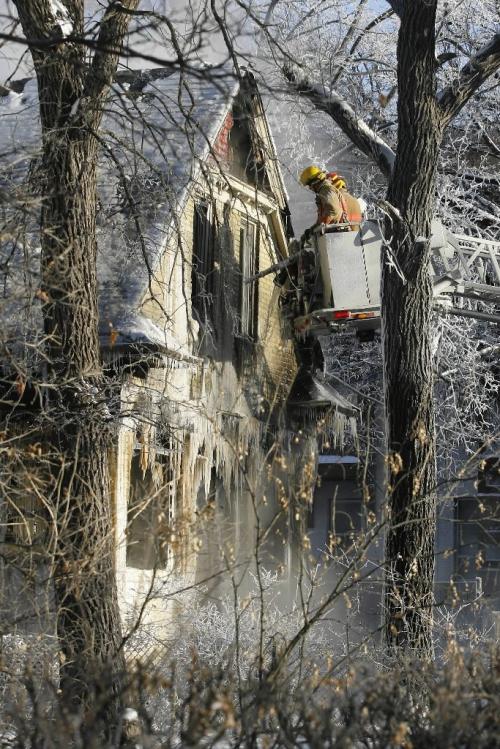 John Woods / Winnipeg Free Press / December 3, 2006 - 061203  - Firefighters work a fire that gutted this home on River Avenue at Scott Sunday Dec 3/06.   According to a firefighter on scene they were called to the location at about 2am.  No one was injured and damages are reported at $350,000.