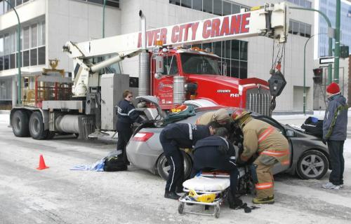 John Woods / Winnipeg Free Press / December 3, 2006 - 061203  - Emergency personnel work to extricate the passenger of a car that was t-boned by a crane at the intersection of York and Edmonton at about 12:30 Sunday Dec 3/06.