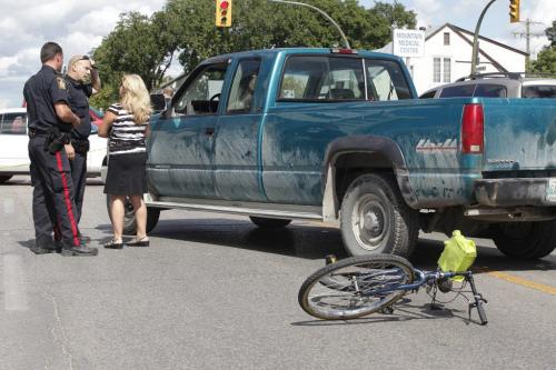 Police investigate at the scene of an serious motor vehicle collision involving a cyclist at the intersection of Mountain Avenue and McGregor Street in Winnipeg Friday, August 19, 2011. The cyclist was transported to hospital in critical condition. John Woods/Winnipeg Free Press