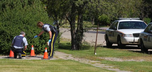 Brandon Sun RCMP officers examine several shell casings and bullets left at the scene of an early morning shooting in Carberry, Man., on Monday. (Bruce Bumstead/Brandon Sun)