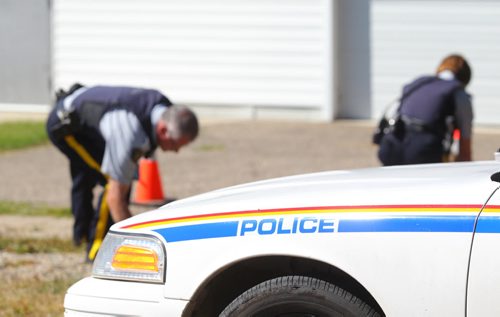 Brandon Sun RCMP officers examine several shell casings and bullets left at the scene of an early morning shooting in Carberry, Man., on Monday. (Bruce Bumstead/Brandon Sun)