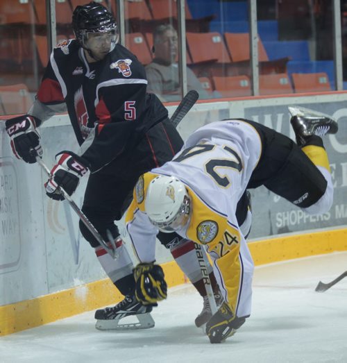 Brandon Sun Wheat Kings' Jens Meilleur was up-ended behind the Moose Jaw net by Warriors' Travis Brown during Friday night's pre-season game at Westman Place. (Bruce Bumstead/Brandon Sun)