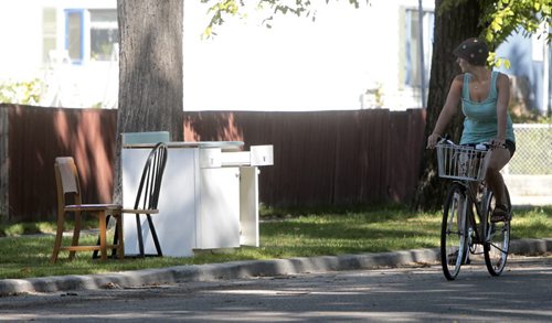 A passerby checks out some chairs and a desk on Sherburn during Giveaway weekend. 110910 - Saturday, September 10, 2011 -  (MIKE DEAL / WINNIPEG FREE PRESS)