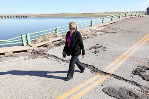 Brandon Sun 27092011 Rally organizer Betty Miller crosses the washed-out Highway 251 bridge over the Souris river east of Coulter, Manitoba on Tuesday morning after the rally. Area residents, farmers and workers gathered to demand action on fixing the bridge from various levels of government. (Tim Smith/Brandon Sun)