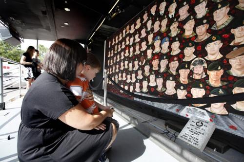 Three year old Carson Turner looks over the memorial plaque with his mom Michelle of a newly unveiled travelling mural of 157 fallen Canadian soldiers, sailors and aircrew ( including his uncle) at the Forks Wednesday afternoon.  The Kinsmen Club of Winnipeg has been selected as one of the stops on the Portraits of Honour Tour which was painted by artist Dave Sopha. Sept 28, 2011 Ruth Bonneville  Winnipeg Free Press