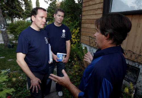 ELECTION - Hugh McFadyen,left, and St. Vital PC candidate Mike Brown,right, work the streets in St. Vital. Here they show their police endorsement t shirts as they talk to resident Harold Rivard.  Oct. 3, 2011 (BORIS MINKEVICH / WINNIPEG FREE PRESS)