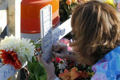 Lorna Bouchard, mother of Ed Anderson, the tow truck driver who died with his girlfriend on Dugald Road, at the crash memorial for the first time. Location is Dugald and Plessis. Here Lorna writes a thoughtful message to her dead son. Oct. 5, 2011 (BORIS MINKEVICH / WINNIPEG FREE PRESS)