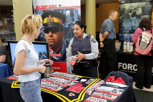 Brandon Sun 05102011 Constable Izza Mian with the RCMP Recruiting Services speaks to a student during the career day in the Knowles-Douglas mingling area at Brandon University on Wednesday. (Tim Smith/Brandon Sun)