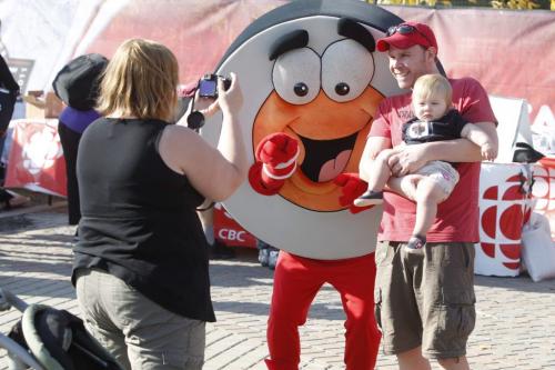 NHL Faceoff 2011 at the Forks. Jennifer Pelland takes a picture of her daughter McKenna and her husband Trevor Didham front of the Scotiabank stage with Peter Puck.  Oct. 6, 2011 (BORIS MINKEVICH / WINNIPEG FREE PRESS)
