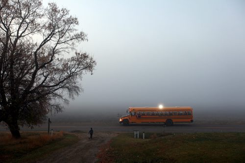 Brandon Sun 13102011 A young boy runs to his waiting school bus amidst thick fog on Grand Valley Rd. on a chilly Thursday morning. (Tim Smith/Brandon Sun)