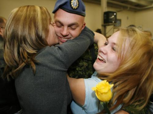 John Woods / Winnipeg Free Press / December 23, 2006 - 061223  - Darin Lampman is welcomed by his excited wife Catharine (L) and daughter Stephanie in the arrival area of 17th Wing Saturday Dec. 24/06.  Fifty three soldiers arrived back from the secret Camp Mirage which supports troupes in Afghanistan.