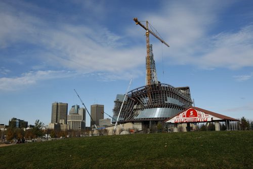 Weather Stdup - Construction update  The Canadian Museum for Human Rights  is nearly  closed in with glass panels  as passerby's enjoy the warm fall day  at the  skate board park at the Forks - update for book project - KEN GIGLIOTTI /  WINNIPEG FREE PRESS /  Oct 31 2011 CMHR