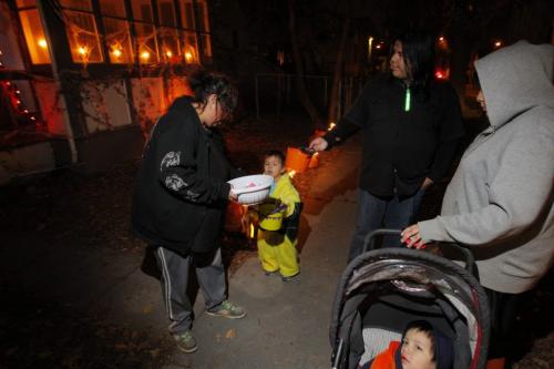 Halloween in the North End. April Hopomani, left, is giving out treats to the kids. Oct. 31, 2011 (BORIS MINKEVICH / WINNIPEG FREE PRESS)