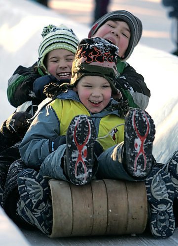BORIS MINKEVICH / WINNIPEG FREE PRESS  061226 (top-bottom) Noah Huebert,9, his sister Glory,7, and little brother Joel,5, enjoy some warm weather on boxing day at the St. Vital Park toboggan slides. The kids came in from Calgary to visit family.